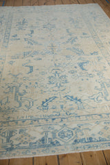 Low-pile texture and time-softened tones of a distressed vintage Ahar carpet at an angle.