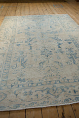 The soft, low-pile texture of a distressed Persian Ahar rug with sky blue and ivory patterns.