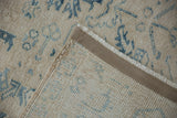 Corner of vintage rug folded to show its hand-knotted foundation and secured side selvage.
