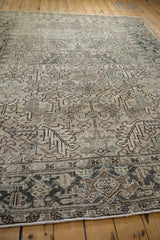 The low-pile, distressed texture and detailed turtle border of a vintage Persian Heriz carpet.