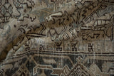 Worn texture showing the knot heads and turtle border design of a vintage Heriz rug.