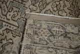 Distressed pile, secured edge, and hand-knotted back of a vintage Persian Heriz rug corner.