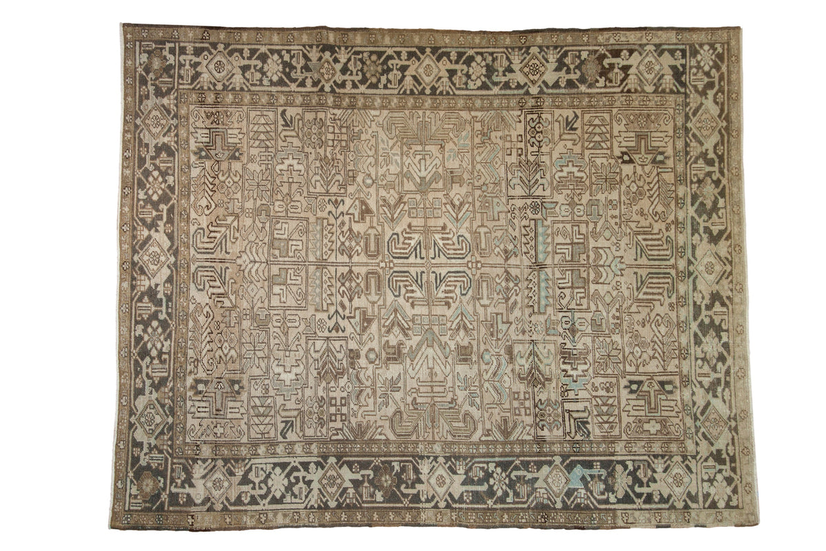A vintage distressed Heriz carpet with a geometric allover design in sand, charcoal, and muted blue.