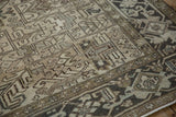 Detail of a distressed Heriz rug's sharp turtle samovar border and geometric field.
