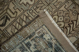 Corner of a vintage Heriz rug showing the hand-knotted foundation and secured side cord.