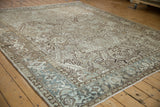 Vintage Heriz carpet viewed from an angle, showcasing its even wear and muted greige and blue tones.