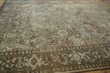 Angled view of a vintage Heriz carpet showing the turtle samovar border and floral field.