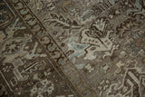 Angled close-up showing the distressed, low-pile texture and knot heads of a vintage Persian Heriz.