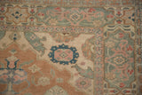 Distressed vintage Kayseri rug corner with cartouche floral border and faded jade tones.