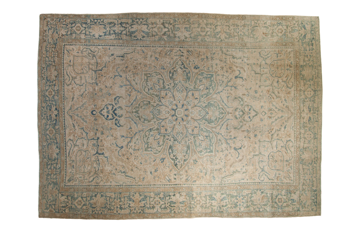 Vintage distressed Ahar carpet with a central starburst medallion and floral field in soft beige, ivory, and sky blue.