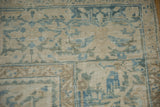 Worn, low-pile texture of a distressed Ahar rug showing foundation in soft blues and sand.