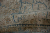A fold in the distressed vintage Ahar carpet revealing its low, hand-knotted texture.