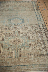 Distressed Karaja runner's geometric patterns with abrashes and jade green and brown tones.