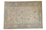 Vintage distressed Heriz carpet with an allover floral design in dusty teal and red on a neutral ivory field.