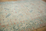 Angled view showing the low, worn pile and turtle samovar border of a vintage Heriz carpet.