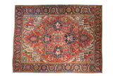 Vintage Heriz carpet with bold quatrefoil medallion, gem-tone red field, and intricate floral motifs.