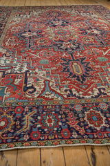 Vintage Heriz carpet showing navy, cherry red border and stylized floral field, intact selvage.