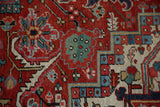 Vintage Heriz carpet's serrated leaf and floral motifs in cherry red and jade green.
