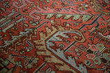 Vintage Heriz carpet with expressive serrated leaves, floral motifs in madder red, blue, camel.