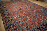 Vivid madder red field with sprawling curvilinear floral motifs and navy blue border detail.