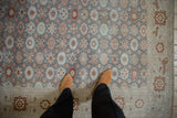 A person's perspective on the vintage Sparta carpet's low pile and slate blue floral field.