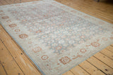 Angled perspective of a vintage Sparta carpet's allover floral pattern in slate blue, terra cotta, and ivory.