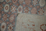 A folded corner showing the hand-knotted foundation and floral pile of a Turkish Sparta carpet.