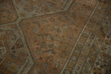 Distressed Kamseh rug detail with visible wear, muted chestnut, rust, and silver geometric patterns.