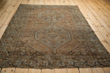 Distressed Kamseh rug corner with faded rust, silver motifs, and visible wear.