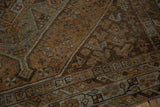 Distressed vintage Kamseh rug detail with earthy geometric patterns in chestnut, rust, and antique silver.