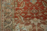 Detail of the Herati motif and mostly even wear on the hand-knotted terracotta pile.