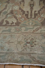 Stylized lion and deer figures in brown and beige on a distressed hand-knotted Sivas carpet.