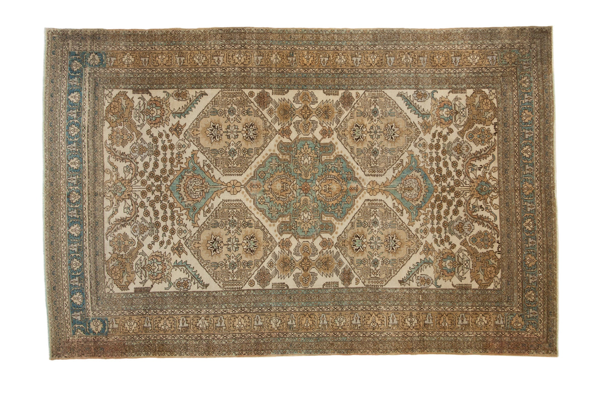 Vintage distressed Ardebil carpet with repeating medallions and floral guls in ivory, sand, and sky blue.