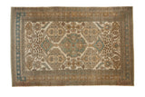 Vintage distressed Ardebil carpet with repeating medallions and floral guls in ivory, sand, and sky blue.