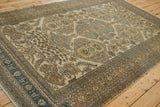 Angled perspective on a vintage Ardebil carpet's intricate floral medallions and time-softened texture.
