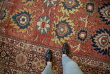 Antique Mahal carpet featuring primitive bold palmettes in madder red, navy, and yellow tones.