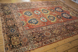 Antique Mahal rug's charcoal border with primitive arabesques, madder red field, and oversized palmettes.