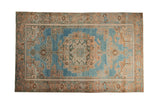 Distressed Hamadan rug with a large geometric medallion in peach and bronze on a faded blue field.