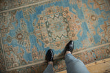 Worn texture on the large peach medallion of a vintage blue Hamadan rug.