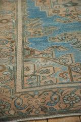 Evenly worn, hand-knotted texture on the corner of a distressed rug in peach and sky blue.