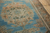 Angled view of the worn, low-pile texture on a vintage Hamadan's peach medallion and border.