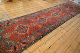 A long perspective of the antique Bakshaish runner's single column of diamond medallions.