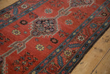 Stylized stepped medallion and serrated floral border on a madder red antique Bakshaish runner.