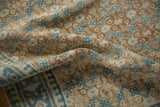 Folded vintage Hamadan rug close-up, revealing even pile wear, dusty blue lattice panels, and pawn motif border.