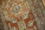 Detailed view of the low-pile texture and exposed knot heads on a distressed Persian Heriz rug.