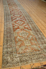 Angled view of a distressed Heriz runner, highlighting its long form and repeating geometric design.