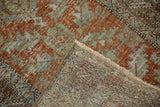 Folded corner of a vintage Heriz runner revealing the hand-knotted foundation and distressed pile.