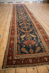 Angled view of the long antique Heriz runner, showing its scale and repeating cypress motif column.