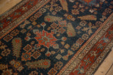 Geometric cypress shrub motifs and low pile texture on an antique navy blue Heriz runner.