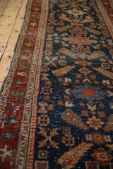 Angled view of the antique Heriz runner showing the texture of its navy blue and brick red pile.